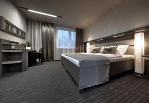 a bedroom with a large bed and a desk at Volcano Spa Hotel in Prague