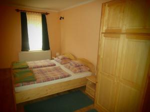 a small bedroom with a bed and a window at Nádkunyhó Vendégház in Hegyhátszentjakab