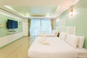 un soggiorno con un grande letto bianco con un arco sopra di Phranang Place- SHA Extra ad Aonang Beach