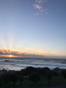 a view of the ocean at sunset at Beachfront apartment in Porto