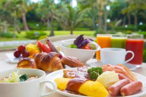 a table with a plate of breakfast foods and drinks at Laguna Garden Hotel in Ginowan