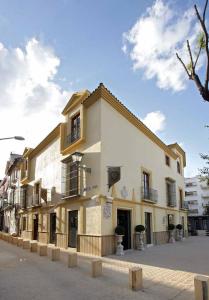 een groot wit gebouw met balkons in een straat bij Sacristia de Santa Ana in Sevilla