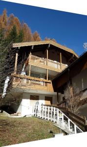 ein großes Holzhaus mit einer großen Terrasse in der Unterkunft Trevisan in Campitello di Fassa