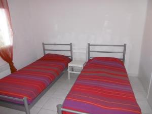 dos camas sentadas una al lado de la otra en una habitación en Holidayland Residence Plein Sud villa 60m2 6 couchages, en Narbonne-Plage