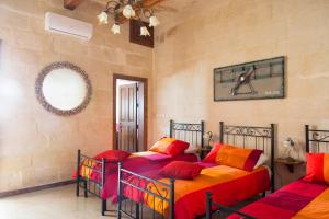 a bedroom with two beds with colorful sheets at Maltese Town House Sliema in Sliema
