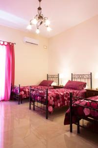 Maltese Town House Sliema في سليمة: غرفة نوم بسريرين مع شراشف وردية