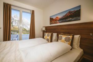 a bedroom with a bed and a window with mountains at Hotel Römerhof in Leukerbad