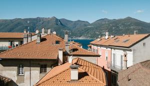 uitzicht op de daken van gebouwen met bergen op de achtergrond bij Residenza Felice in Luino