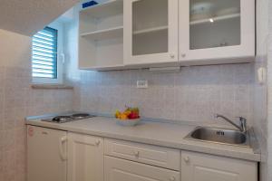 a kitchen with white cabinets and a bowl of fruit on the counter at Villa Cetina in Omiš