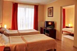 Posteľ alebo postele v izbe v ubytovaní Apartamenty & Restauracja Janus