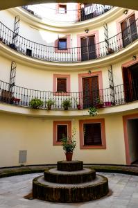 een gebouw met een ronde binnenplaats met een potplant bij AlohaMundi Campana in Sevilla