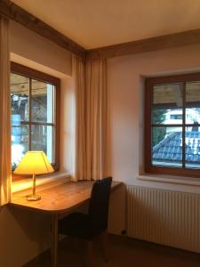 a room with a table with a lamp and two windows at Ferienwohnungen Obex in Mieders