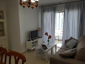 a living room with a couch and a tv at Apartamento centrico in Almuñécar