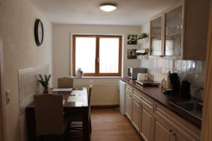 a kitchen with a table and a sink and a window at Gästehaus Kril in Rust