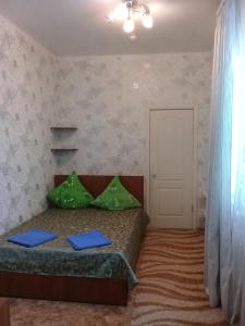 サラトフにあるYunas Hotelのベッドルーム1室(緑の枕が付いたベッド1台付)