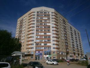 スィクティフカルにあるComfort apartment on Pervomayskaya 20の駐車場車を停めた大きな建物