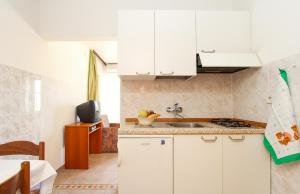 een keuken met witte kasten en een spoelbak bij Apartments Lili in Medulin +51 foto's