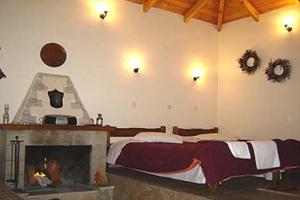 a bedroom with a bed and a fireplace at Lithos in Sirmbáni