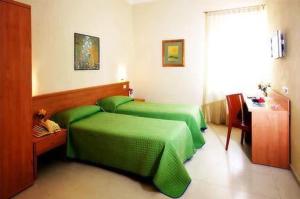 una camera con due letti verdi e un tavolo di Borgo San Martino a Bra
