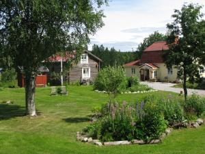 a yard with a house and a garden with flowers at Stuga Lugnvik in Lugnvik
