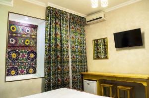a bedroom with a wall with a fireplace and a tv at Jahongir in Samarkand