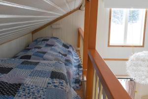 een bed in een kleine kamer met een raam bij Stuga Lugnvik in Lugnvik