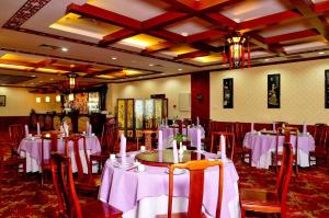 Un comedor con mesas y sillas con mantel blanco. en Don Chan Palace Hotel & Convention, en Vientiane