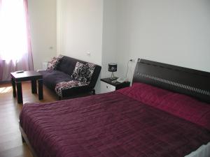 a bedroom with a bed and a couch at Hotel Grig in Yerevan