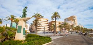 una estatua en medio de una calle con palmeras en Homely Apartments Blasco Ibañez, en Torrevieja