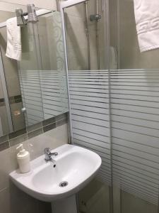a bathroom with a sink and a glass shower at Lx Center Guesthouse in Lisbon
