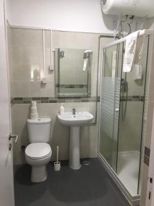a bathroom with a toilet and a sink and a shower at Lx Center Guesthouse in Lisbon