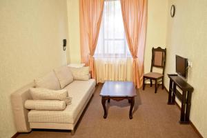 un soggiorno con divano, tavolo e finestra di Dobrye Traditsii Hotel a Krasnodar