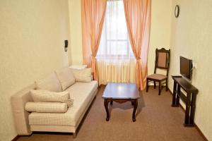 a living room with a couch and a table and a window at Dobrye Traditsii Hotel in Krasnodar