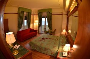 a bedroom with a bed and a red couch at Grand Hotel Montesilvano in Montesilvano