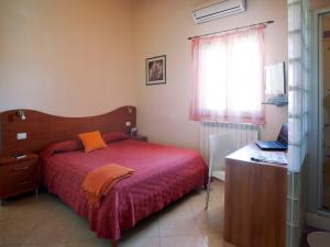 une chambre avec un lit, un bureau et une fenêtre dans l'établissement Motta Residence Hotel, à Motta SantʼAnastasia