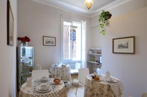 - un salon avec deux tables et une fenêtre dans l'établissement B&B Cangrande di Danese-Viviani, à Vérone