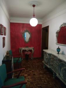 sala de estar con paredes rojas y espejo en Como en tu propia casa en Granada