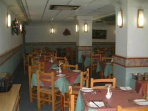 un comedor con mesas y sillas en un restaurante en Relax Inn Hotel, en St Paul's Bay