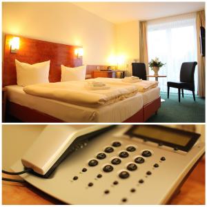 Habitación de hotel con cama y mando a distancia en Hotel am Holzhafen, en Stade