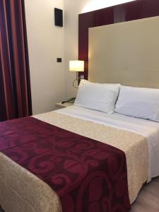 una camera da letto con un grande letto con una coperta rossa di Albergo Panorama a Frascati