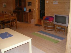 a living room with a television and a table at Pensionat Sågknorren in Bygget