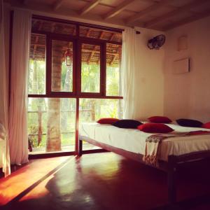 a bedroom with two beds and a large window at Les 3 Elephants in Cherai Beach