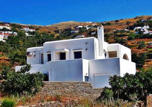 una casa blanca en la cima de una colina en Green view village, en Pitrofós