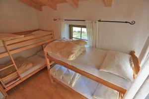 a bedroom with two bunk beds and a window at Appartamenti Pollam in Pozza di Fassa