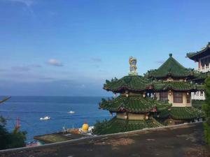 a pagoda on top of a hill next to the ocean at Happy Holiday Xiaoliuqiu in Xiaoliuqiu +39 photos