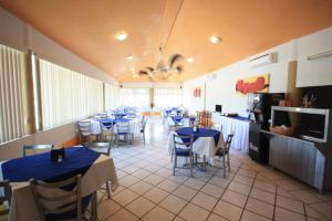 ein Restaurant mit blauen Tischen und Stühlen sowie einer Küche in der Unterkunft Hotel Splash Inn in Silao
