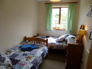 a bedroom with two beds and a window at Bakehouse in Great Ellingham