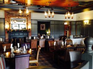 a restaurant with tables and chairs in a room at Fir Trees Hotel in Strabane