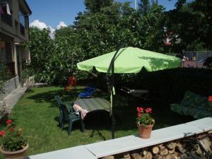 einen grünen Regenschirm und einen Tisch und Stühle im Hof in der Unterkunft Ai Tre Fichi in Cedas