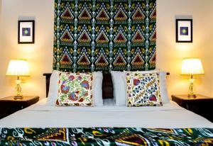 a bedroom with a bed with a headboard and two lamps at Jahongir Guest House in Samarkand